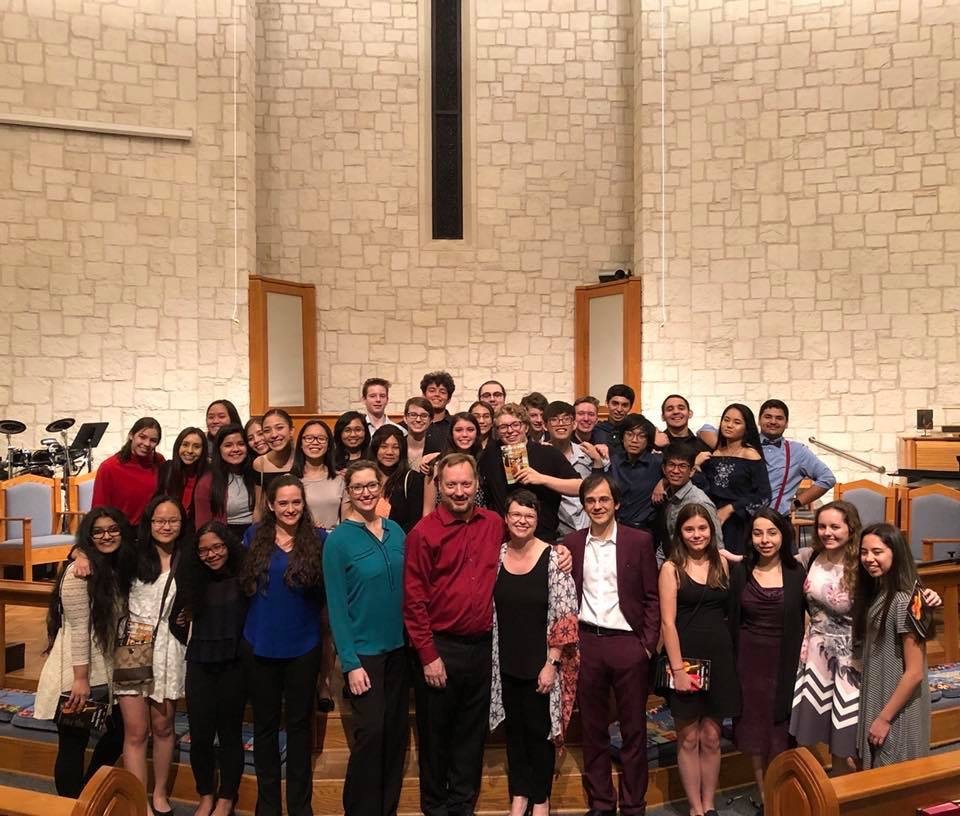 Large group of students surround performers smiling after a concert